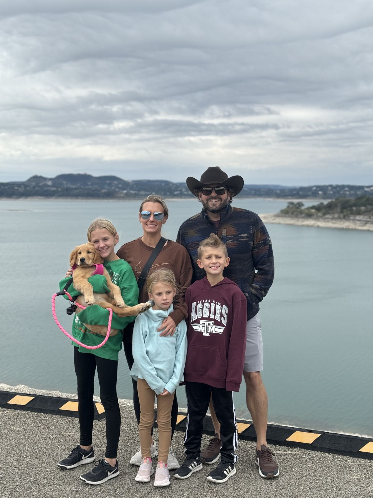 Tom with his wife, three children, and the family puppy at the lake