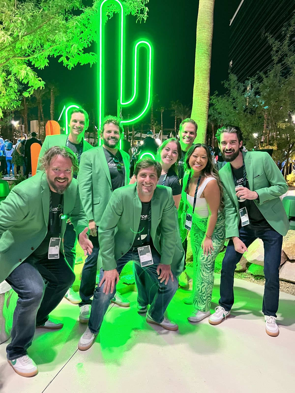 The SourceDay team in matching green jackets at a company event